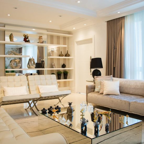 Sala de estar de uma casa com decoração moderna e móveis nas cores branco e cinza